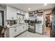 Updated kitchen featuring white cabinets, open shelving, and stainless steel appliances at 2124 W Maricopa St, Phoenix, AZ 85009
