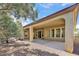 A covered back patio with an arch design, desert landscaping, and many windows at 13055 W Eagle Talon Trl, Peoria, AZ 85383