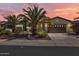 Charming single-story home with a two-car garage, desert landscaping, and mature palm trees against a stunning sunset at 13055 W Eagle Talon Trl, Peoria, AZ 85383