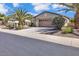 Charming single-story home with a 2-car garage, desert landscaping, and mature palm trees at 13055 W Eagle Talon Trl, Peoria, AZ 85383