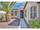 Inviting single-Gathering home featuring a charming front entrance with stone accents and a palm tree at 13055 W Eagle Talon Trl, Peoria, AZ 85383