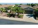 Beautiful home with a well-manicured front yard featuring palm trees and a spacious driveway leading to a two-car garage at 13055 W Eagle Talon Trl, Peoria, AZ 85383