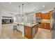 A modern kitchen with granite countertops and stainless steel appliances and an open design leading into the living room at 13055 W Eagle Talon Trl, Peoria, AZ 85383
