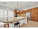 Well-lit kitchen with granite countertops, stainless steel appliances, breakfast bar, and wood cabinetry at 13055 W Eagle Talon Trl, Peoria, AZ 85383