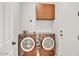 Functional laundry room with modern washer and dryer, upper cabinets, and convenient access at 13055 W Eagle Talon Trl, Peoria, AZ 85383