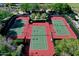 Aerial view of tennis courts with green playing surfaces and red borders, surrounded by mature landscaping at 13055 W Eagle Talon Trl, Peoria, AZ 85383