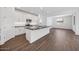 Contemporary kitchen with white cabinetry, stainless steel appliances, island with sink, and wood-look tile flooring at 16766 W Yucatan Dr, Surprise, AZ 85388