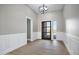 Bright entryway with wood-look floors, white wainscoting, and a modern chandelier at 31559 N Pamela Dr, Queen Creek, AZ 85144