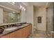 The bright bathroom features dual sinks with a dark countertop and a large glass shower enclosure at 7117 E Rancho Vista Dr # 4006, Scottsdale, AZ 85251