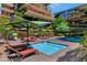 A beautiful pool area with lounge chairs, umbrellas, and greenery at 7117 E Rancho Vista Dr # 4006, Scottsdale, AZ 85251