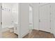 Bright bathroom with a toilet, sink, and shower with a white tile surround, and wooden-look tile floors at 20306 W Turney Ave, Buckeye, AZ 85396