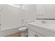 Bright bathroom with a toilet, sink, and bathtub with a white tile surround, and wooden-look tile floors at 20306 W Turney Ave, Buckeye, AZ 85396