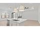 Bright kitchen island with a sink, modern faucet, and pendant lights, overlooking the adjacent living space at 20306 W Turney Ave, Buckeye, AZ 85396