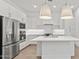 Modern kitchen with white cabinets, stainless steel appliances, a kitchen island, and stylish pendant lighting at 20306 W Turney Ave, Buckeye, AZ 85396