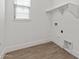 Bright laundry room with wooden floors, built-in shelves, and a window providing natural light at 20306 W Turney Ave, Buckeye, AZ 85396