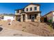 Two-story house with brown garage door and stone accents at 11417 S 50Th Ave, Laveen, AZ 85339