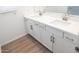 Bathroom featuring a double sink vanity with modern cabinetry and laminate wood-style flooring at 2428 W Rowel Rd, Phoenix, AZ 85085