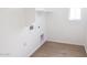 Clean, white laundry room with laminate wood-style flooring and modern connections at 2428 W Rowel Rd, Phoenix, AZ 85085