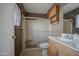 Bathroom featuring a vanity with a mirror, a shower with glass doors, and a toilet at 10619 W Clair Dr, Sun City, AZ 85351