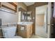 Small bathroom featuring a sink with mirror and a toilet, leading into another room at 10619 W Clair Dr, Sun City, AZ 85351