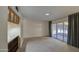 Inviting living room with plush carpeting, a sunlit sunroom, and built-in shelving at 10619 W Clair Dr, Sun City, AZ 85351