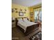 Bedroom featuring yellow walls, wooden floors, and decorative duck art to add a unique touch at 15576 W Coral Pointe Dr, Surprise, AZ 85374