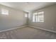 Bright bedroom featuring neutral carpet, light gray walls, and a large window at 31969 N 117Th Ave, Peoria, AZ 85383