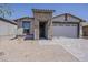 Charming single-story home featuring a stone-accented entrance, a two-car garage, and low-maintenance desert landscaping at 31969 N 117Th Ave, Peoria, AZ 85383