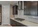 Close-up of a kitchen with stainless steel hood, gas cooktop, white countertops and stylish cabinets at 31969 N 117Th Ave, Peoria, AZ 85383
