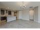 Open-concept kitchen and living room with stylish lighting, tile floors, neutral color scheme, and ample space at 31969 N 117Th Ave, Peoria, AZ 85383