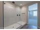 Modern bathroom featuring glass-enclosed shower, marble walls, and contemporary fixtures at 31985 N 117Th Ave, Peoria, AZ 85383