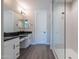 Modern bathroom featuring a double sink vanity, quartz countertop, and glass enclosed shower at 31985 N 117Th Ave, Peoria, AZ 85383