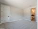 Neutral bedroom with ensuite bathroom, carpet floors, and a large window at 31985 N 117Th Ave, Peoria, AZ 85383