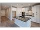 Modern kitchen featuring white cabinetry, an island with a black countertop, and stainless steel appliances at 31985 N 117Th Ave, Peoria, AZ 85383
