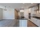 Bright kitchen featuring an island with a black countertop, stainless steel appliances, and an adjacent living area at 31985 N 117Th Ave, Peoria, AZ 85383