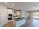 Kitchen featuring an island, white cabinets, stainless appliances, and an open layout connecting to the living spaces at 31985 N 117Th Ave, Peoria, AZ 85383
