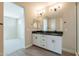 Modern bathroom featuring double sinks, granite countertops, and sleek black fixtures in a bright, neutral color palette at 32018 N 117Th Ave, Peoria, AZ 85383