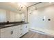 Bathroom with dual sinks, a vanity, and a glass-enclosed shower with modern fixtures at 32018 N 117Th Ave, Peoria, AZ 85383