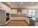 Bright kitchen with white cabinets, granite countertops, stainless steel appliances, and modern fixtures at 32018 N 117Th Ave, Peoria, AZ 85383