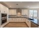 Modern kitchen featuring stainless appliances, granite countertops and bright white cabinets at 32018 N 117Th Ave, Peoria, AZ 85383