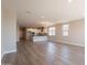 Open-concept living room with hardwood floors and plenty of natural light adjoining kitchen at 32018 N 117Th Ave, Peoria, AZ 85383