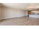 Open-concept living room showcasing wood floors and seamless flow to the modern kitchen at 32018 N 117Th Ave, Peoria, AZ 85383