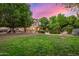 Large, lush backyard featuring a covered patio, outdoor grill, pool and mature trees at 1201 W Washington Ave, Gilbert, AZ 85233
