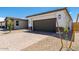 Beautiful home exterior with a paved driveway, stone accents, and a modern garage door at 1329 W Via De Olivos Dr, San Tan Valley, AZ 85140