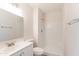 Bathroom featuring a single sink vanity, tiled shower, and brushed nickel fixtures at 7508 W Osborn Rd, Phoenix, AZ 85033