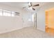 Cozy bedroom featuring carpet, neutral walls, a ceiling fan, and access to the bathroom at 7508 W Osborn Rd, Phoenix, AZ 85033