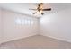 Bedroom with neutral carpet, a window, and a ceiling fan with light fixture at 7508 W Osborn Rd, Phoenix, AZ 85033