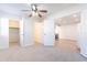 Bedroom with a ceiling fan, neutral walls and floors, and open doorway to the kitchen at 7508 W Osborn Rd, Phoenix, AZ 85033