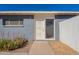 Charming front entrance with a white door, xeriscaping, and painted brick exterior in blue at 7508 W Osborn Rd, Phoenix, AZ 85033