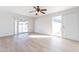 Bright living room with light wood-look floors, neutral walls, a ceiling fan, and sliding glass doors at 7508 W Osborn Rd, Phoenix, AZ 85033